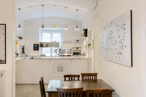 a dining room with a table and chairs and a kitchen at Tomato Urban Retreat in Turin