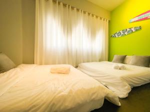 ABS Pool Condo في نانوان: سريرين في غرفة بجدران خضراء وصفراء