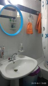 a bathroom with a white sink and a mirror at Παραθαλάσσια κατοικία στην παραλία Κατακόλου in Pýrgos