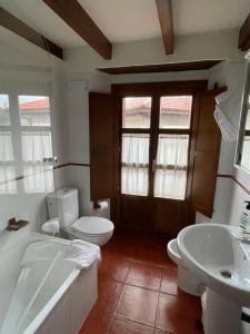 un bagno con un water, una vasca e un lavandino di Apartamentos el Cueto de los Collado a Villanueva de Pría Altre 32 foto
