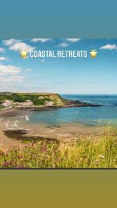a picture of a beach with the words coastal retreat at Coastal retreats, Beech rise, primrose valley in Filey