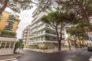 un edificio de apartamentos en una calle con árboles en Sunrise Palace, en Lido di Jesolo