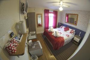 a bedroom with a bed with a red bedspread at The Eastleigh in Skegness