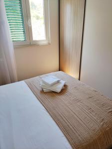 a bed with two white towels sitting on top of it at Apartment Marica in Stomorska