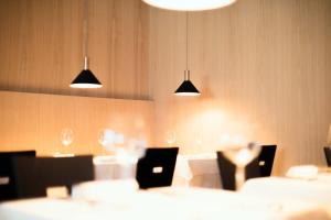 un comedor con mesas, sillas y luces en Schgaguler Hotel, en Castelrotto