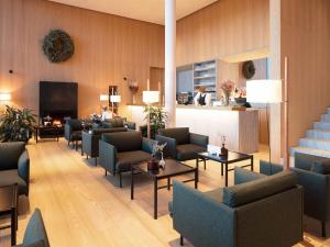 a lobby with couches and chairs and a fireplace at Schgaguler Hotel in Castelrotto
