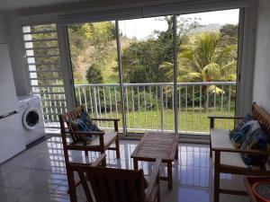 a kitchen with a table and chairs and a large window at Chez coco appartement AZURE in Petit Bourg