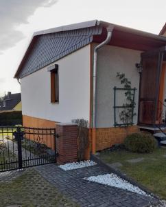 a small white house with a black fence at Ferienhaus Harzidylle in Siptenfelde