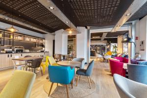 a restaurant with colorful chairs and tables in a room at Campanile Epinal Centre - Gare in Épinal