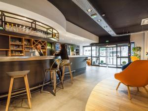 a bar with two people sitting at a counter at Campanile Epinal Centre - Gare in Épinal