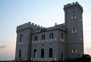 a large white building with lights on it at Hotel Castello Miramare in Genova