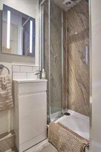 a bathroom with a shower and a sink and a tub at Seòmar Beag in Oban