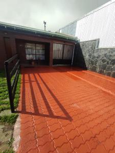 patio in mattoni rossi con un edificio e un cancello di Casa amplia estacionamiento privado. a Ushuaia