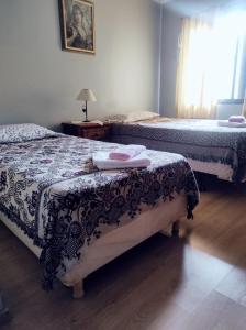 una camera con due letti e un tavolo con una lampada di Casa amplia estacionamiento privado. a Ushuaia