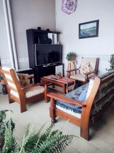 un soggiorno con 2 sedie e una TV di Casa amplia estacionamiento privado. a Ushuaia