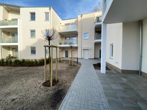 ein Gebäude mit Bäumen vor einem Bürgersteig in der Unterkunft Fewo unweit Warnemünde Sobierajczyk in Markgrafenheide in Rostock