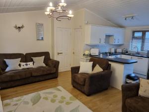 ein Wohnzimmer mit 2 Sofas und einer Küche in der Unterkunft Troutbeck 12 in Windermere