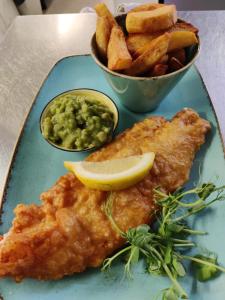 a blue plate with fish and chips and a lemon slice at White Horse Inn in Chester