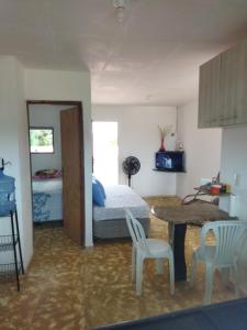 a bedroom with a bed and a table and chairs at Apartamento in São José da Coroa Grande