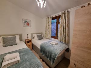 1 Schlafzimmer mit 2 Betten und einem Fenster in der Unterkunft Troutbeck 12 in Windermere