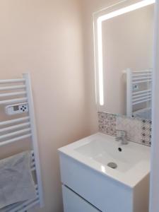 a white bathroom with a sink and a mirror at Maison charmante à Saint-Blimont avec jardin in Saint-Blimont
