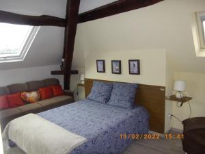 a bedroom with a bed and a couch at sérénite normande in Bolbec