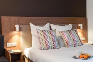 エピナルにあるCampanile Epinal Centre - Gareのベッド(枕付)、オレンジのトレイ