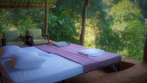 un letto in una camera con due sedie di Chalet in the Jungle a Kaduwela