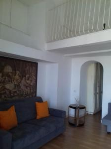 ein Wohnzimmer mit einem blauen Sofa und orangefarbenen Kissen in der Unterkunft House Efria in Positano