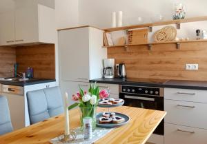 a kitchen with a wooden table with flowers on it at Bergbauernhof Stauder - Hirschbergalpakas in Lendorf