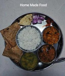 un plato de comida con arroz y diferentes tipos de comida en ELITE HOME en Mahābaleshwar
