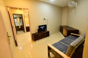 a small room with a television and a mirror at GRACE RESIDENCY in Tirūr