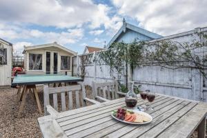 una mesa de picnic con una bandeja de fruta y copas de vino en Sandy Lane Cottage in Reydon by Air Manage Suffolk, en Southwold