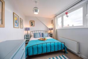 a bedroom with a bed and a window at Sandy Lane Cottage in Reydon in Southwold