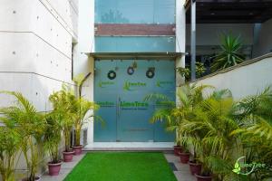 una puerta de garaje azul con plantas delante en Lime Tree Sector 29 Gurgaon Sushant Lok at Iffco Metro en Gurgaon