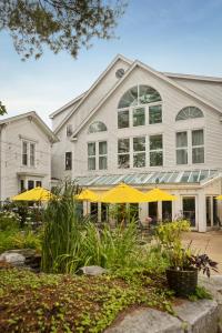 a building with yellow umbrellas in front of it at The Harraseeket Inn & Event House in Freeport