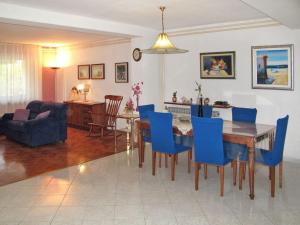uma sala de estar com uma mesa de jantar e cadeiras azuis em house Divna em Valbandon