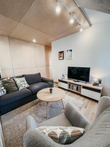 a living room with a couch and a tv at Old Town Apartment in Marijampolė