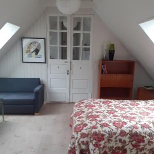 1 dormitorio con 1 cama y 1 sofá azul en Sølyst, en Silkeborg
