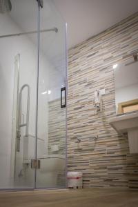 uma casa de banho com um chuveiro e uma parede de vidro em Apartamentos turisticos HAZ AMIGO em Muxía