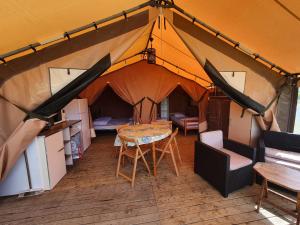 eine Aussicht über ein Zelt mit einem Tisch und Stühlen in der Unterkunft Camping Les Chagnelles in Le Perrier