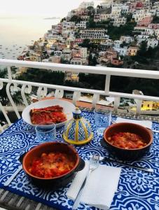 einen Tisch mit zwei Speisen auf dem Balkon in der Unterkunft House Efria in Positano