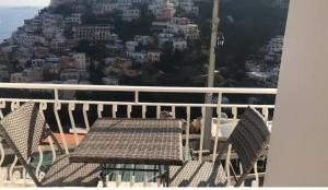 einen Tisch und Stühle auf einem Balkon mit Stadtblick in der Unterkunft House Efria in Positano
