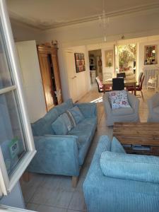 a living room with a blue couch and chairs at Les Angelots in Condom