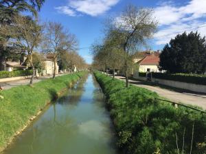 a canal in the middle of a street at Les Angelots in Condom