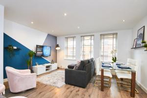 a living room with a couch and a table at Stunning 2 bed Apartment - Central Location in Leeds