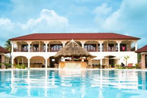 a resort with a swimming pool and a building at Paje Blu Boutique Hotel in Paje