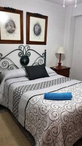 Un dormitorio con una cama con una almohada azul. en Apartamento Armonía:céntrico, tranquilo y acogedor, en Elda