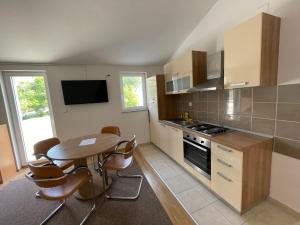 a kitchen with a table and a table and chairs at Petros Apartments Pag in Pag