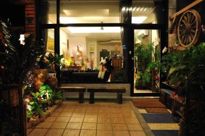 花蓮市にあるBeautifl Sweet Warm B&Bの出入口のベンチに座るぬいぐるみの店